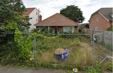 A fenced in yard with a large blue barrel in front of a house

AI-generated content may be incorrect.